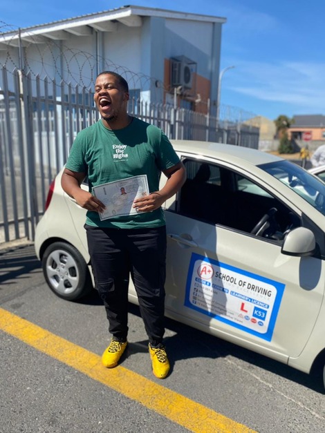 A+ learner celebrating beside the training car